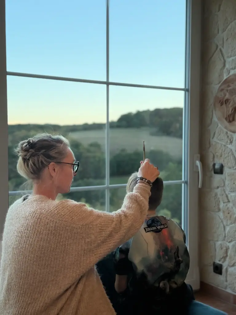 Marion Faul begleitet ein Kind mit dem Meridianstift am Kopf, Blick zum Landschaftsfenster